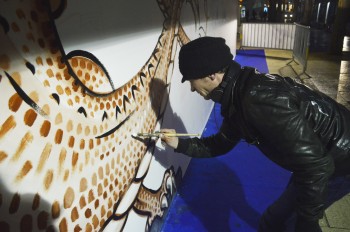 Yann Picard de la Vitrine Ephémère dessine un dragon sur le mur des Libertés Chéries